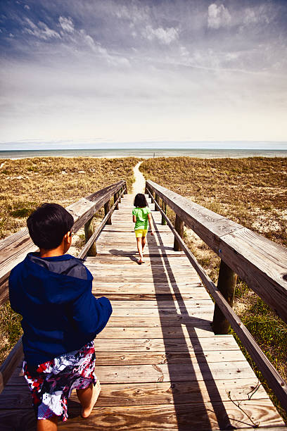 crianças de viagem - beach family boardwalk footpath - fotografias e filmes do acervo