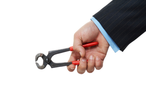 Man in suits holding rusty pliers in hand