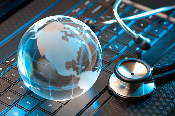 stethoskop und globus auf einer laptop - globe keyboard stock-fotos und bilder