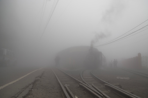 Ghum, darjeeling, west bengal india,22 april 2022 the highest toy train station ghum in the darjeeling where the unesco declared heritage steam train chucks through the mountain in fog