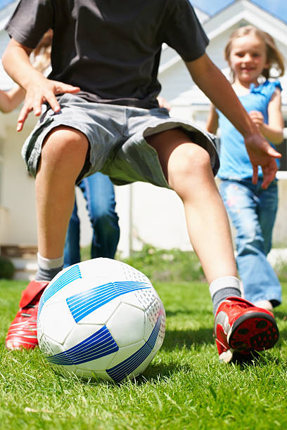 istock Young boy playing soccer with his friends 183820310