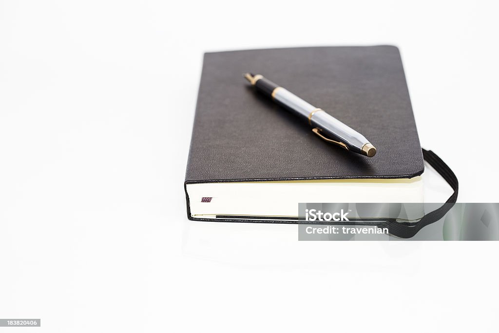 Notebook and a pen Notebook and a pen on white background. Black Color Stock Photo