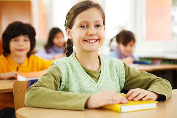 istock Smiling girl sitting in the classroom 183820512