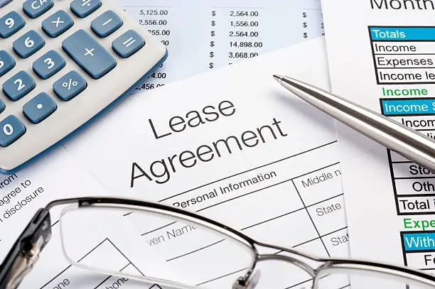 Photo of Lease Agreement Form with pen, calculator