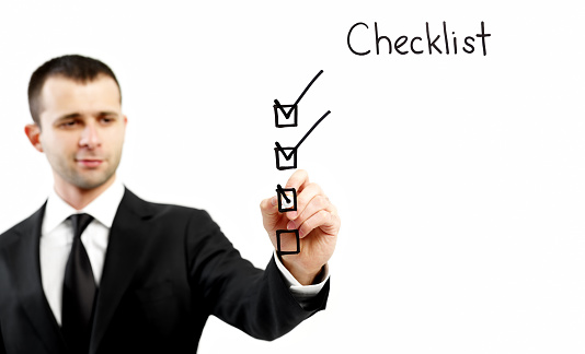Businessman filling a checklist on screen