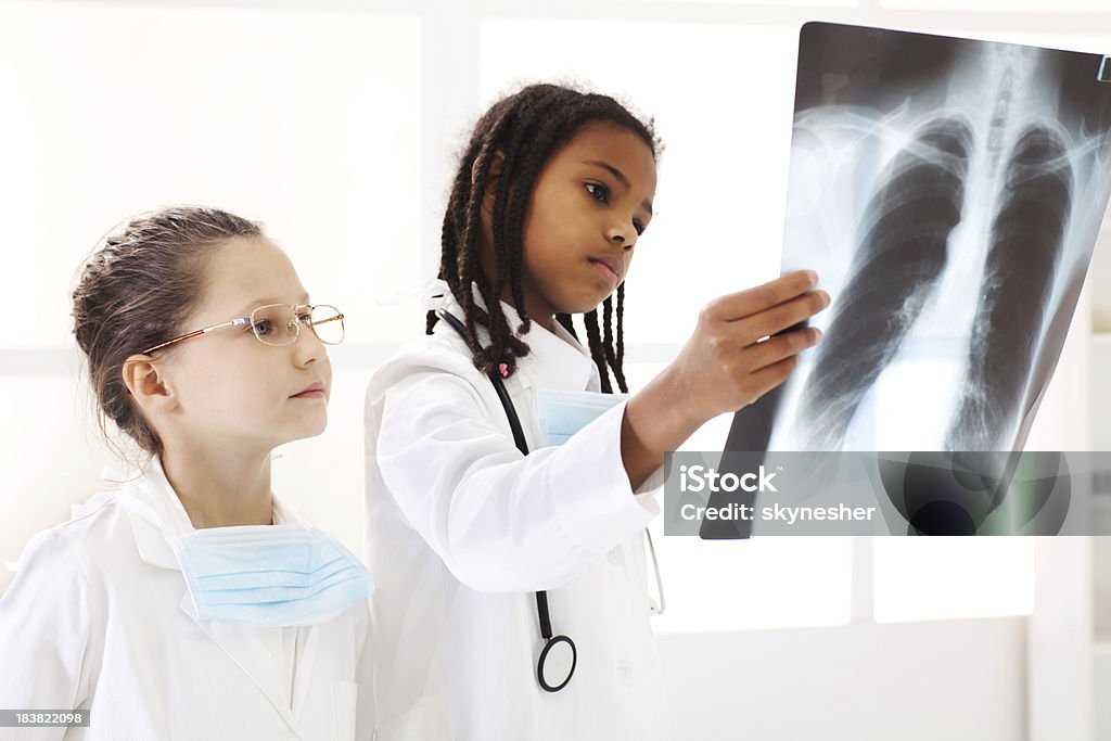 Pediatra team verifica una lastra radiografica. - Foto stock royalty-free di Bambino