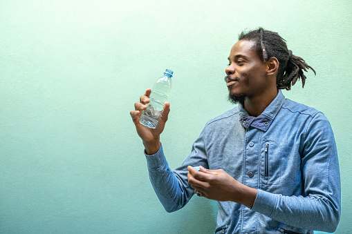 Portrait of a man holding a plastic bottle with water.