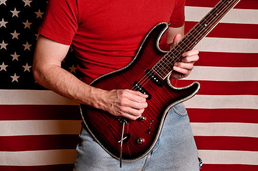 Guitar player in front of American Flag. 