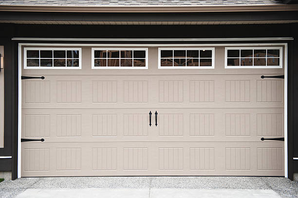 istock A beige two car garage door with paneled windows along top 183823038