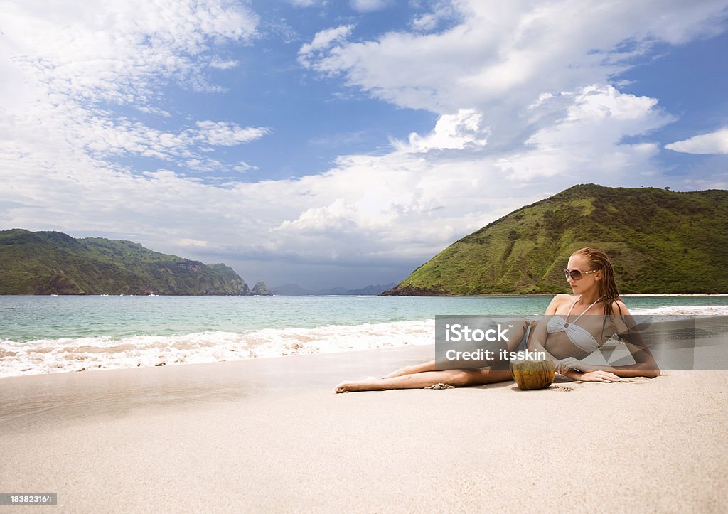 Kobieta z kokosem na plaży - Zbiór zdjęć royalty-free (Beżowy)