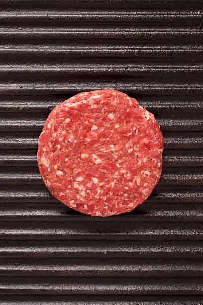 Raw burger over grill