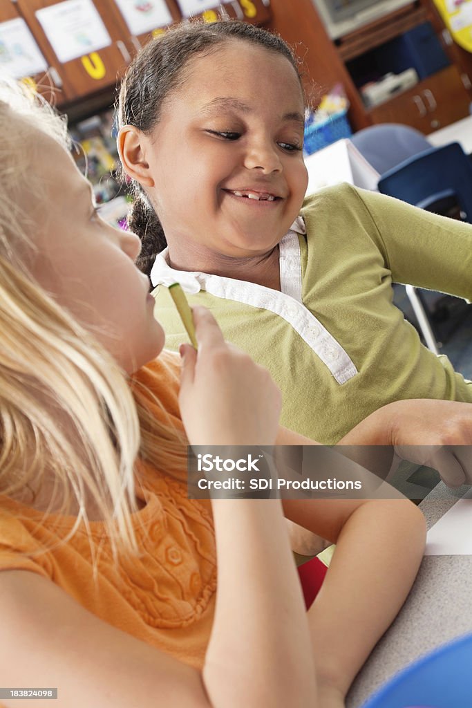 Menina na classe com amigos olhando no trabalho - Foto de stock de 6-7 Anos royalty-free