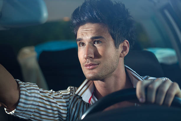 istock Man looking at rear view mirror while driving a car 183824395