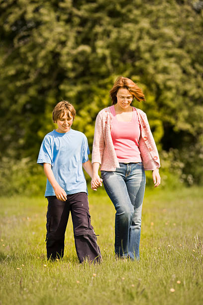 mãe e filho caminhando em inglês verão meadow - pink pants summer two people - fotografias e filmes do acervo