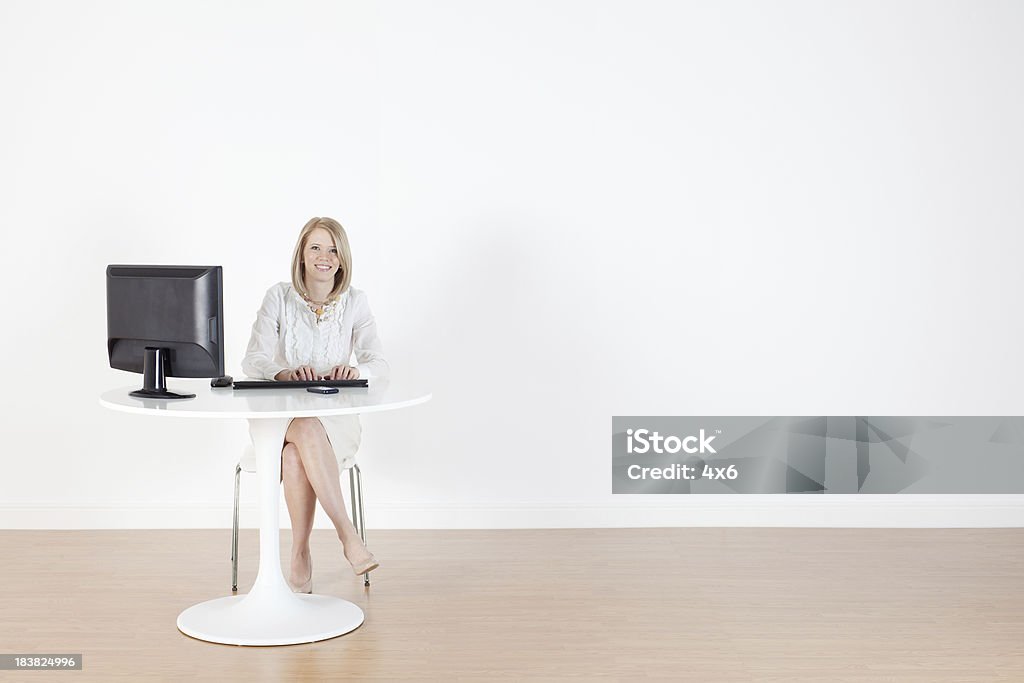 Businesswoman working on a computer Businesswoman working on a computerhttp://www.twodozendesign.info/i/1.png Desk Stock Photo