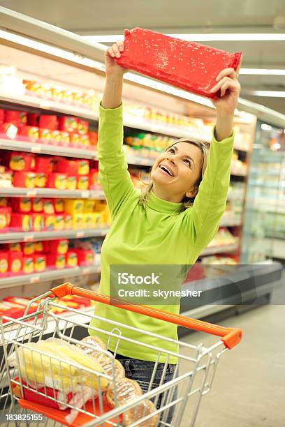 Mulher Feliz Segurando Os Géneros Alimentícios No Grande Supermercado - Fotografias de stock e mais imagens de Adulto