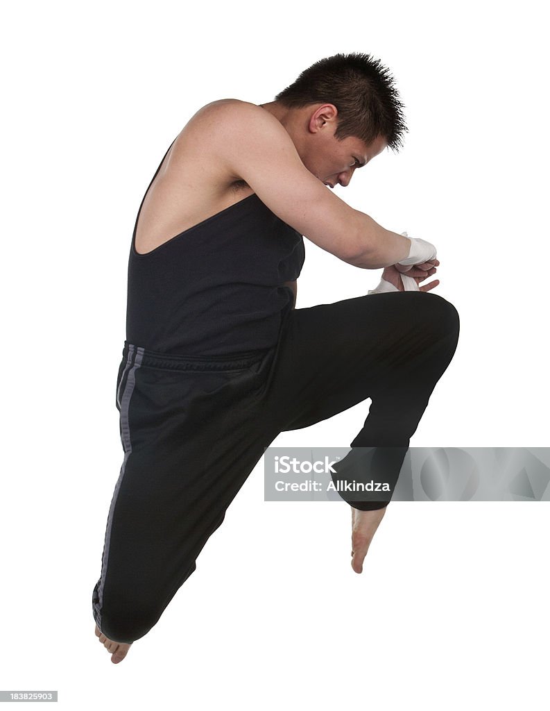 martial arts flying knee to head a young athletic asian male in a fighting martial arts jump with knee to the head pose Asian and Indian Ethnicities Stock Photo