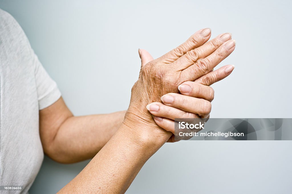 Elderly woman with Arthritis in her hands Elderly woman holding her arthritic hands Arthritis Stock Photo