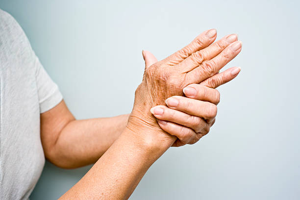 Elderly woman with Arthritis in her hands Elderly woman holding her arthritic hands arthritis stock pictures, royalty-free photos & images