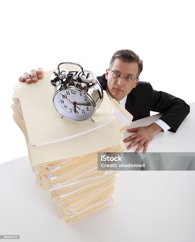 Business Deadline This is a conceptual photo of a businessman with a lot of work to do and not a lot of time. The background above the man's head bleeds to a pure white allowing for endless copy space.There are similar images in the lightbox below: Tall - High Stock Photo