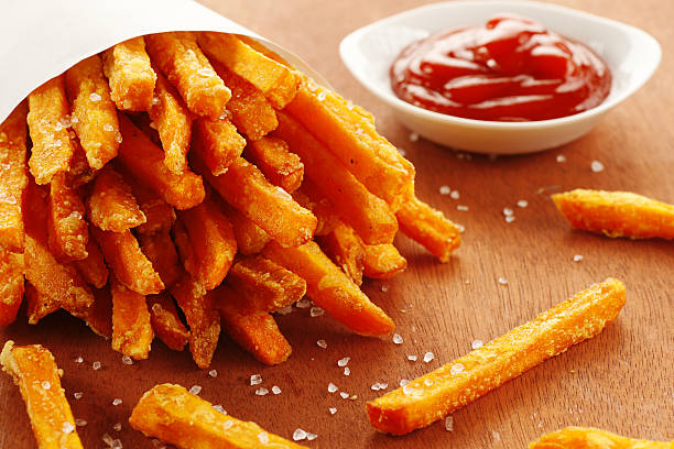 An emptied out cup of sweet potato fries and tomato ketchup Freshly made sweet potato fries with catsup. Sweet Potato Fries stock pictures, royalty-free photos & images