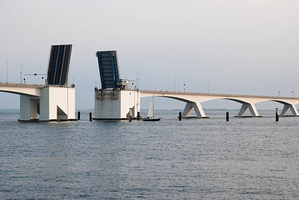 The famous Zeeland Bridge in the Netherlands opened up for the passage of sailboats. Sunset hours.
