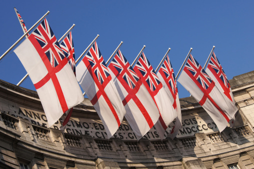 The most luxurious Hotel D'Angleterre in Copenhagen with Danish flags on a summer sunny day. Copenhagen, Denmark - July 26, 2023