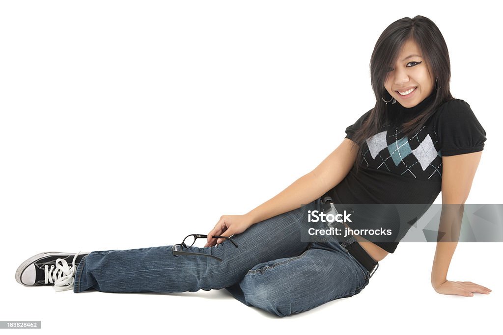 Cheerful Casual Young Asian Woman Sitting on Floor Photo of an casual young woman sitting on the floor; isolated on white. 18-19 Years Stock Photo