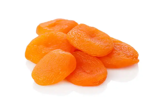 Photo of A stack of dried apricots against a white background