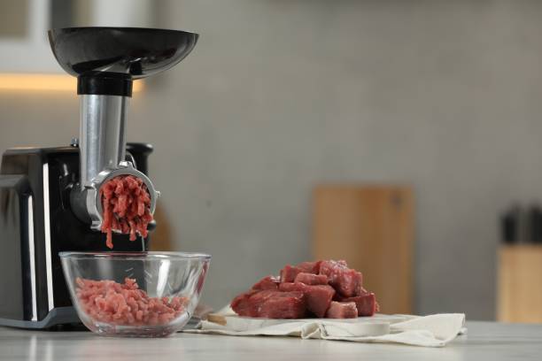istock Electric meat grinder with beef mince on white table in kitchen, space for text 1838291598