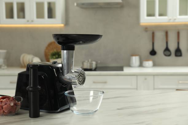 istock Electric meat grinder with beef mince on white table in kitchen, space for text 1838292629