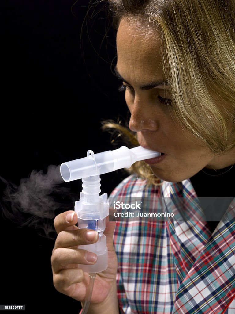 Una donna utilizza un nebulizzatore preferita come trattamento per l'asma. - Foto stock royalty-free di Asmatico