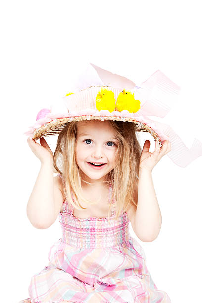 Beautiful young blonde girl with a big smile and wearing a big pink floppy hat. Isolated on white studio background