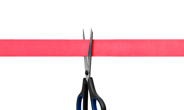 istock Scissors cutting red ribbon isolated on white 183829803