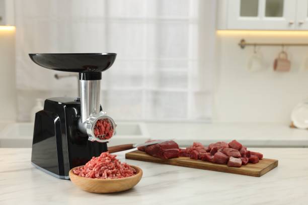 istock Electric meat grinder with minced beef on white marble table in kitchen, space for text 1838300460