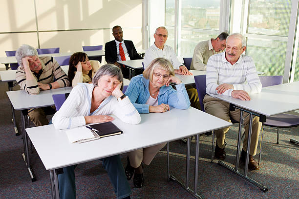 istock School for seniors...Bored senior students  and black young student 183830121