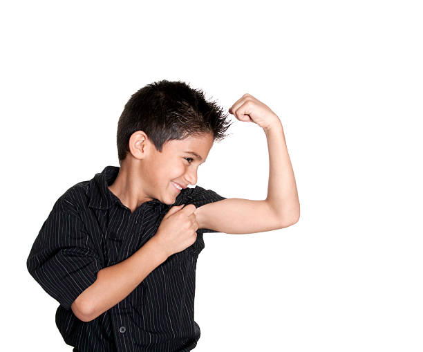 可愛らしいヒスパニック男の子た腕の筋肉を示す ストックフォト
