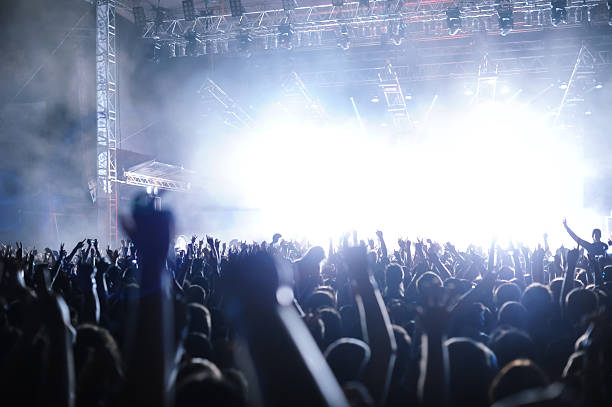 istock Rock'n'roll gig (rock concert), multiple people silhouettes hands screaming dancing 183830721