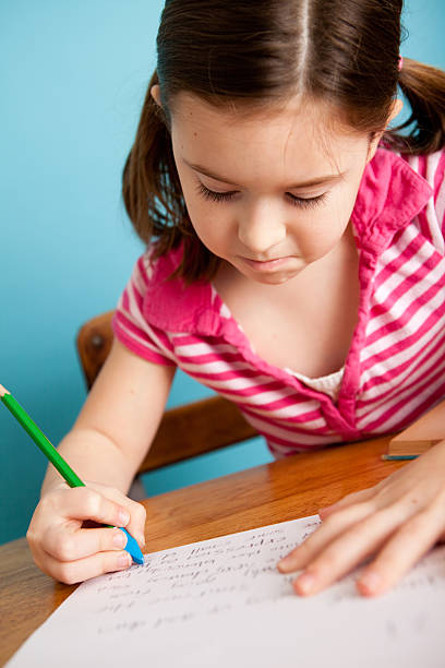istock Young Girl Student Erasing Writing in School Desk 183830977