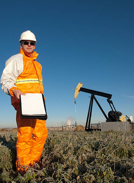 operaio addetto all'estrazione di petrolio in sicurezza prodotti in oltre pumpjack - oil pump oil industry prairie field foto e immagini stock