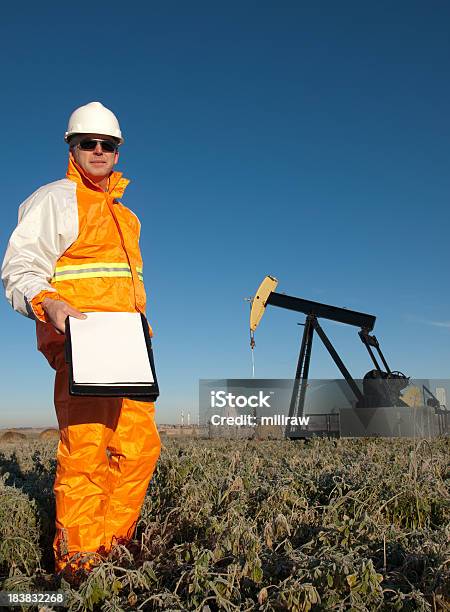 Oil Worker In Safety Gear At Well Pumpjack Stock Photo - Download Image Now - Agriculture, Canada, Hardhat