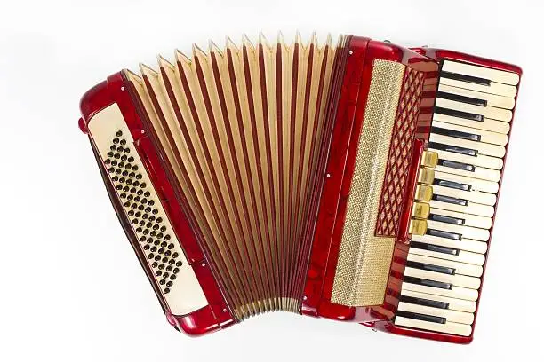 "Photo of a red accordion, isolated on white."