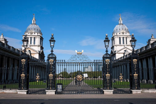 Ceremonial gates into the Old Royal Naval College at Greenwich. Canary Wharf can be seen across the River Thames.
