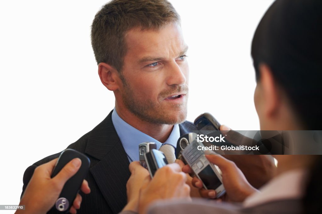 Business man giving interview Closeup of business man giving interview with executives recording his speech using mobile phones 30-39 Years Stock Photo