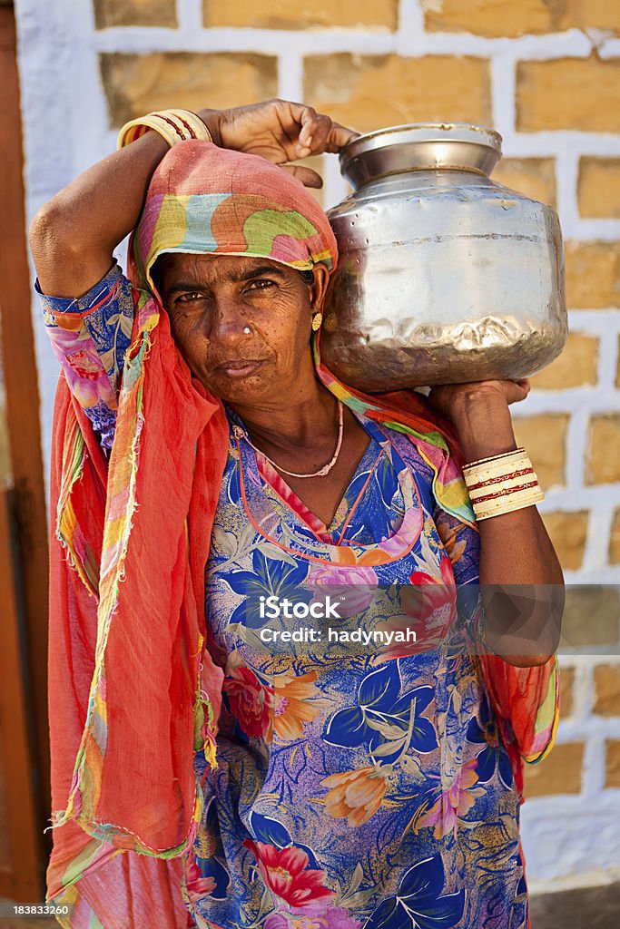 Indian woman carrying water from well "Indian woman carrying water to the village, Thar Desert, Rajasthan, India." Adult Stock Photo