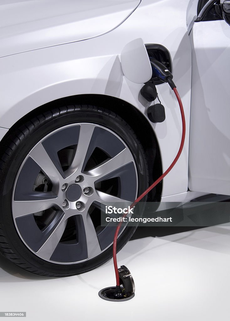 Electric car charging with plug Detail of an electric car or hybrid car recharging the battery with plugged in power cord coming from the floor.Also available: Electric Car Stock Photo
