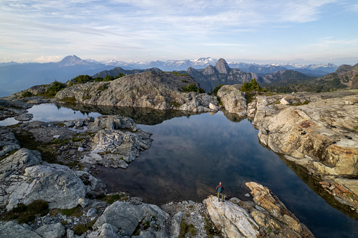 Aerial view of hiker above mountain lake and mountain ranges