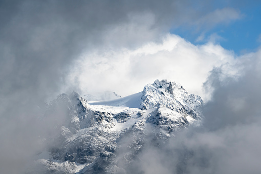 Aerial view of mist rising from snowcapped mountains and alpine