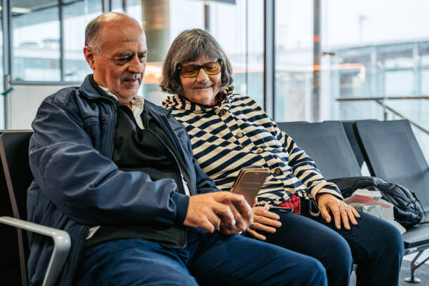 istock Senior Couple Using Smartphone At Departure Terminal While Waiting For Their Flight At The Airport 1838349468