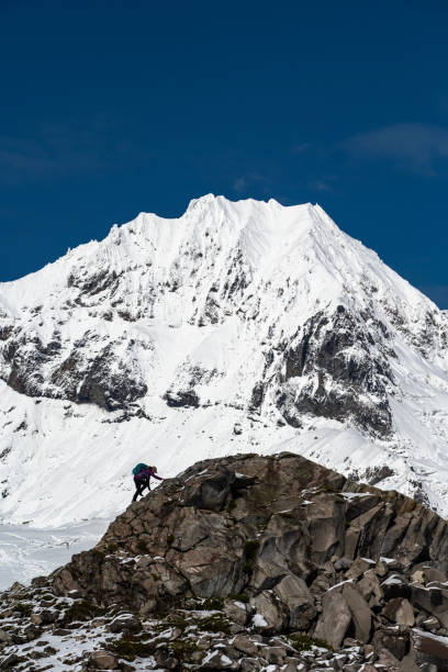 istock Hiker pauses on ridge below snowcapped mountains 1838352036